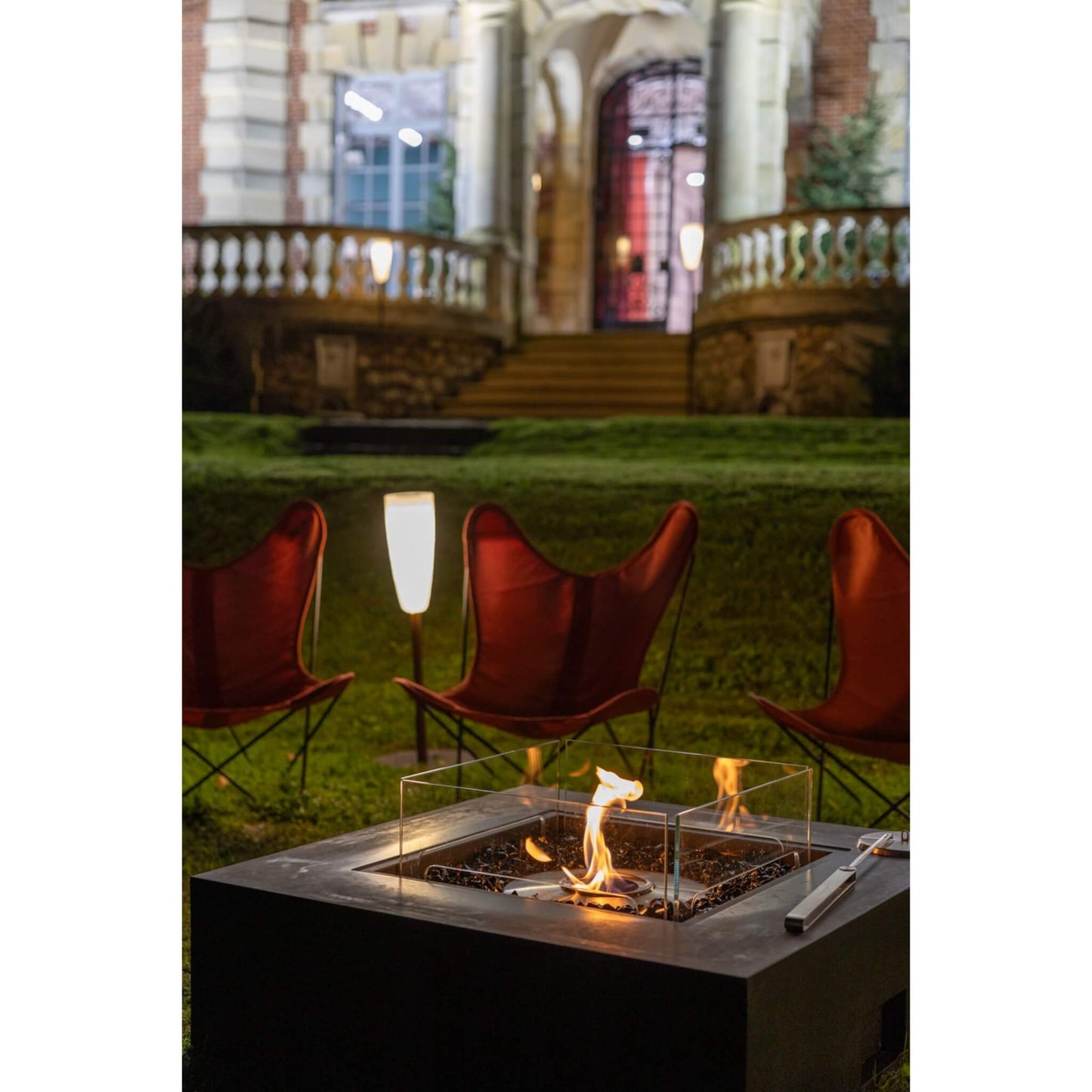 Fire pit with chairs and a lamp in an outdoor setting
