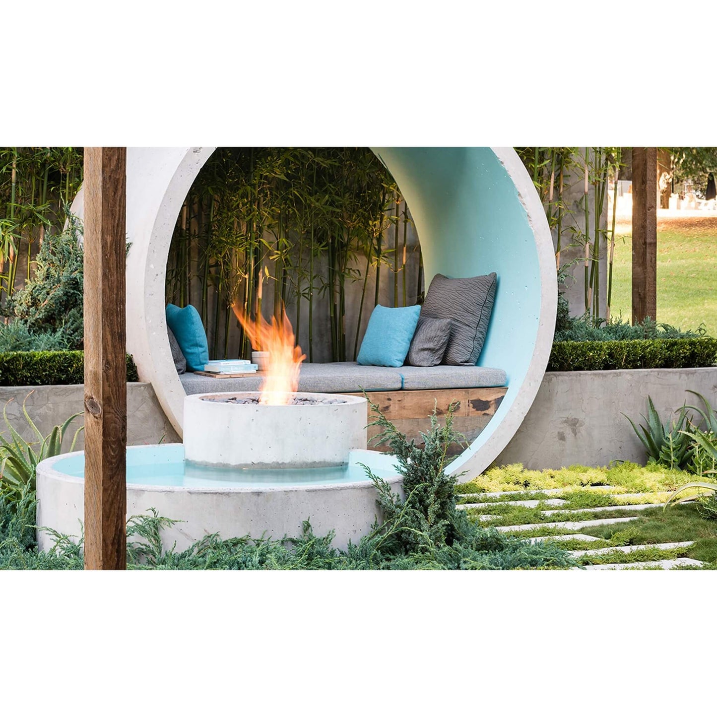 Modern outdoor seating area with a fire pit and circular concrete bench.