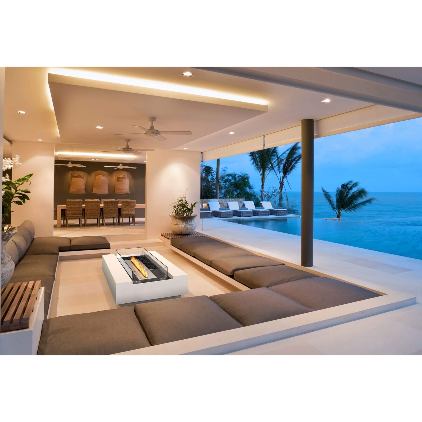 Cosmo 50 Linear Bio Ethanol Concrete Fire Pit Coffee Table in Bone white situated in an outdoor lounge area