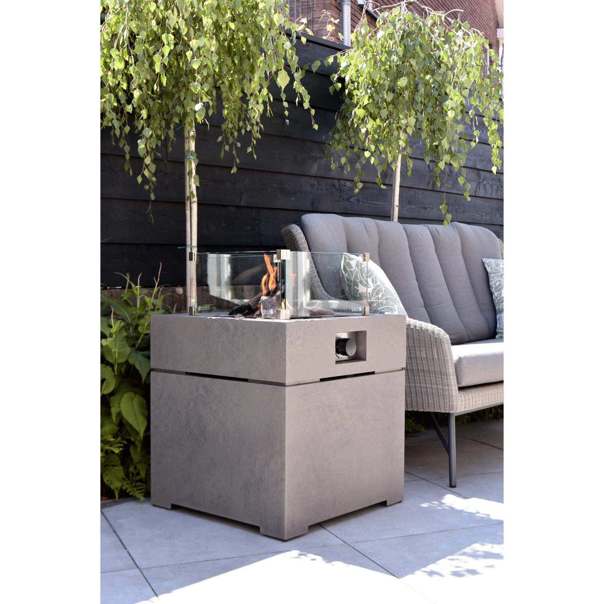 Cosibrixx 60 Concrete Effect Square Gas Fire Pit Table with lit fire and glass screen on an outdoor garden patio