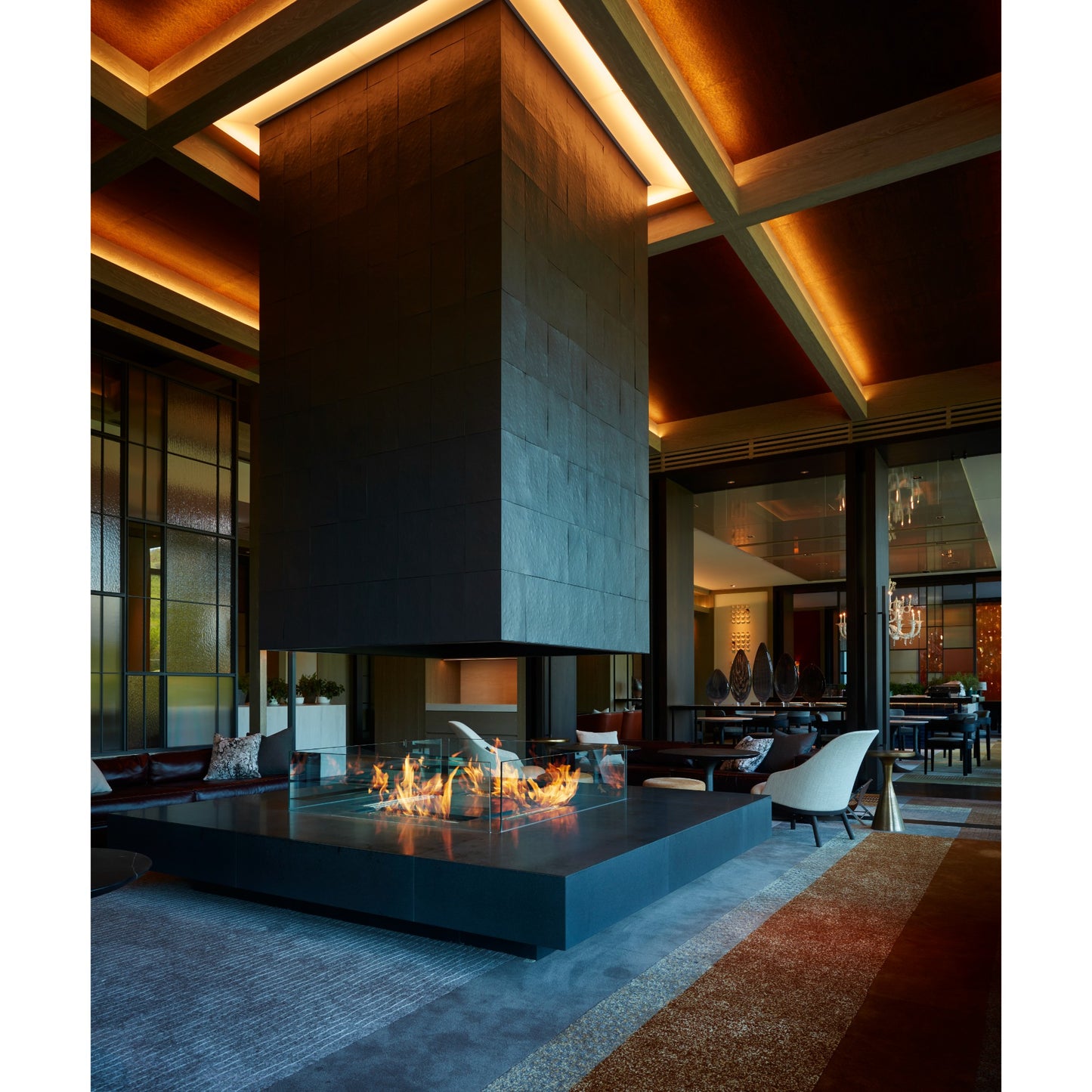 Modern indoor setting with a fire pit and high ceiling