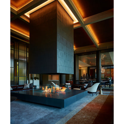 Modern indoor setting with a fire pit and high ceiling
