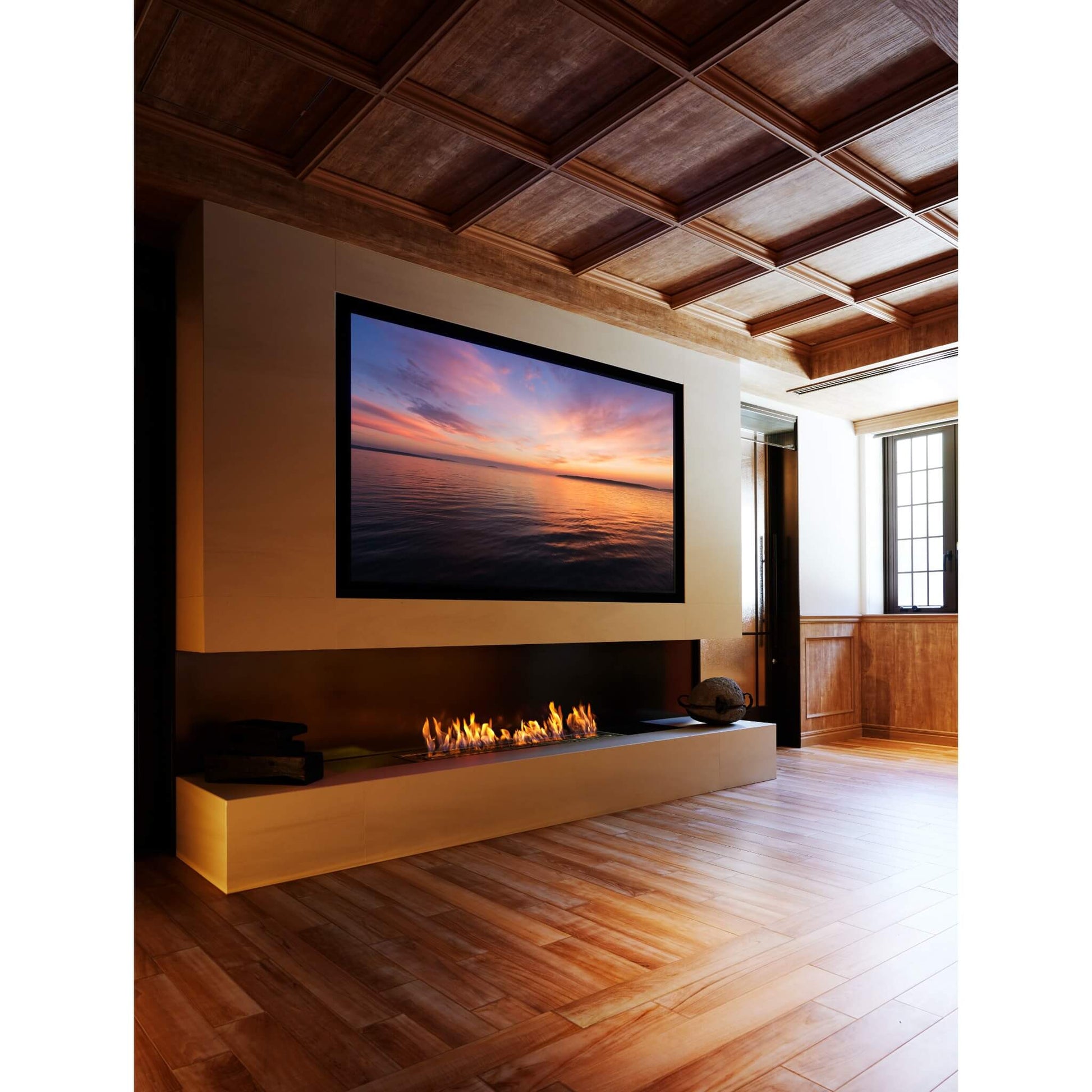 Modern living room with a fireplace and wall-mounted TV displaying a sunset.
