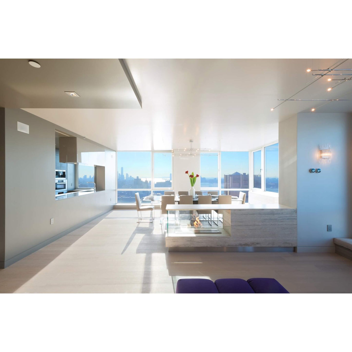 Modern kitchen and dining area with large windows overlooking a cityscape.