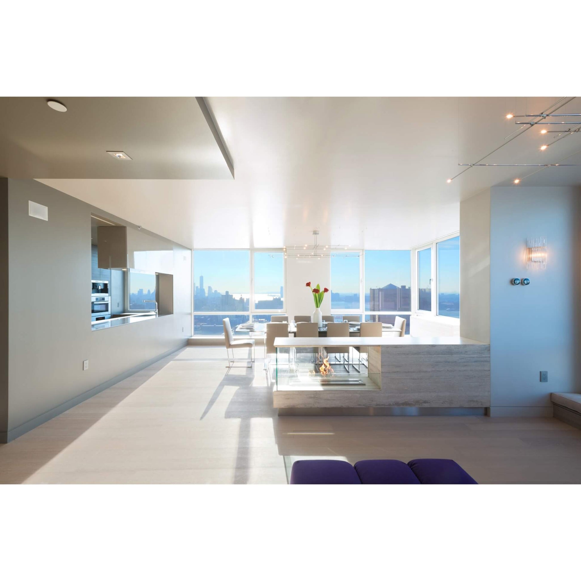 Modern kitchen and dining area with large windows overlooking a cityscape.