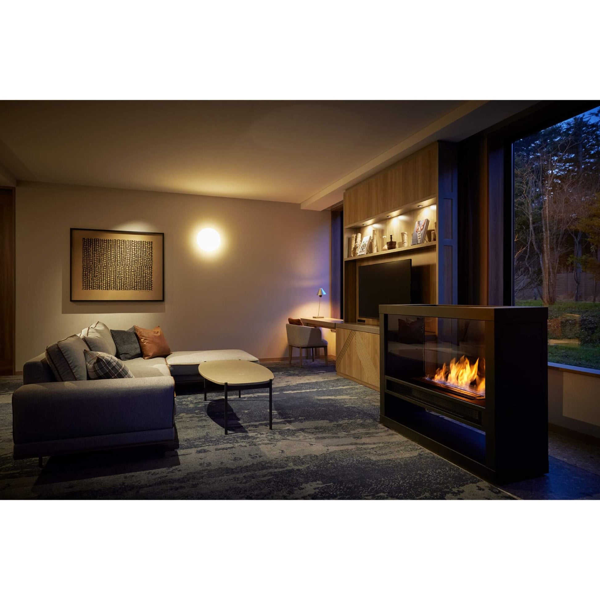 Modern living room with a fireplace, sofa, and wall art.