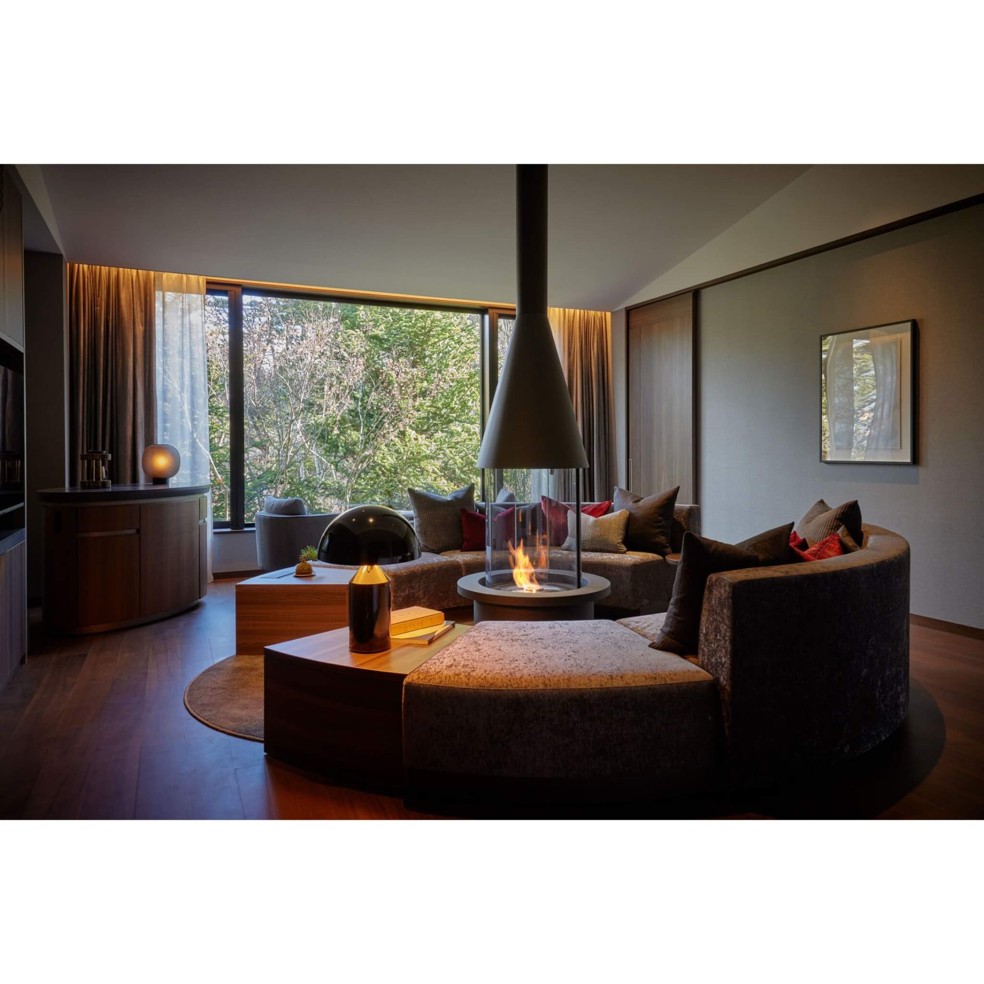 Modern living room with a fireplace and large windows.