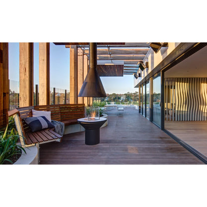 Modern outdoor patio with wooden deck, seating area, and glass walls.