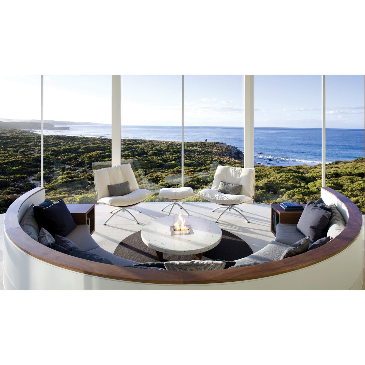 Modern outdoor seating area with a fire pit and ocean view