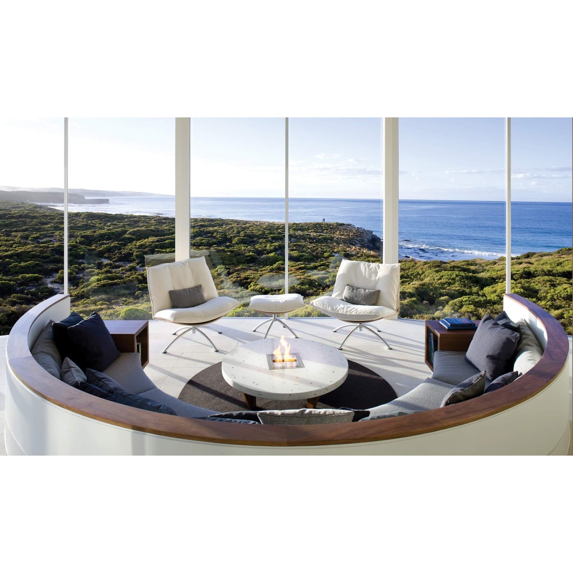 Modern outdoor seating area with a fire pit and ocean view