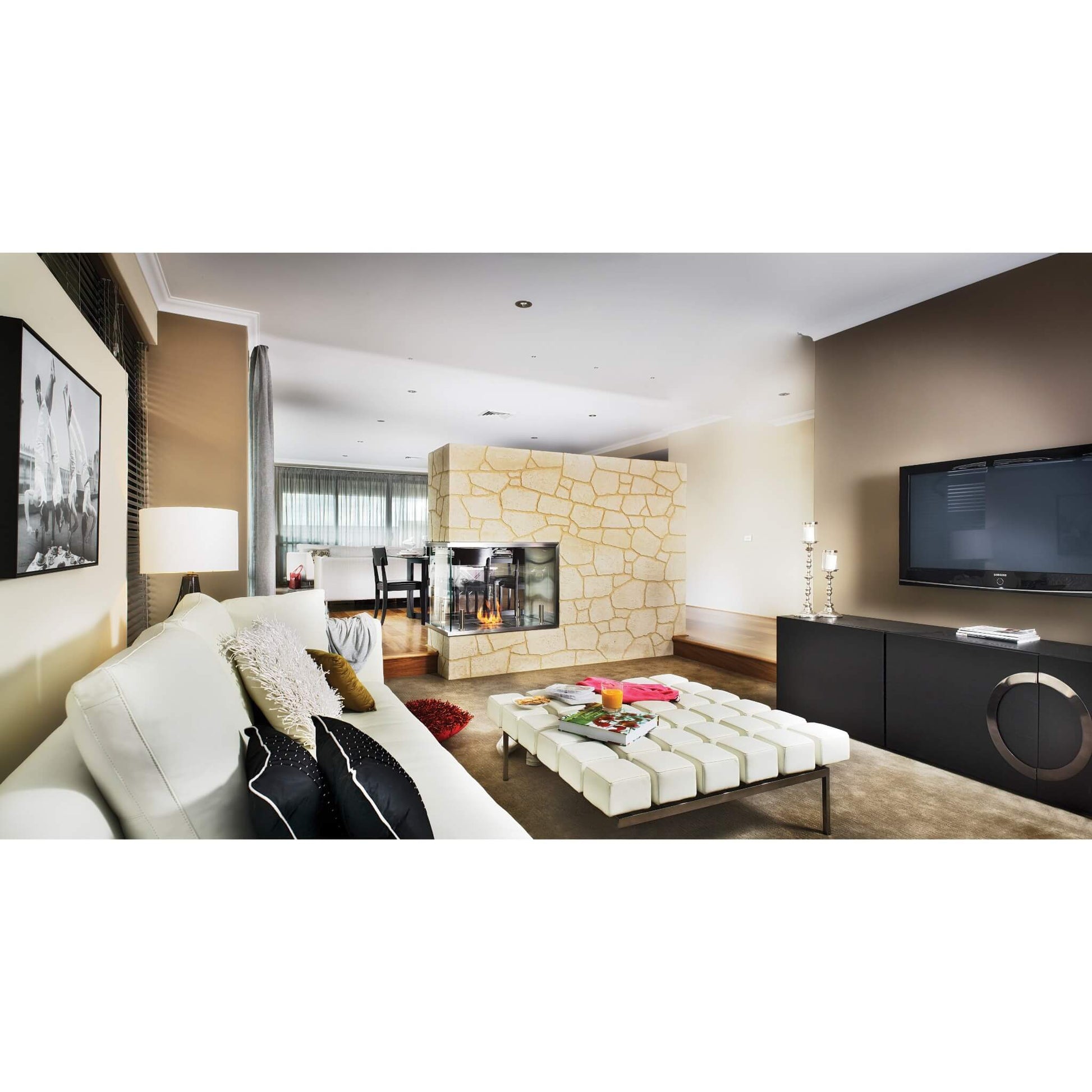 Modern living room with white sofa, coffee table, and wall-mounted TV.