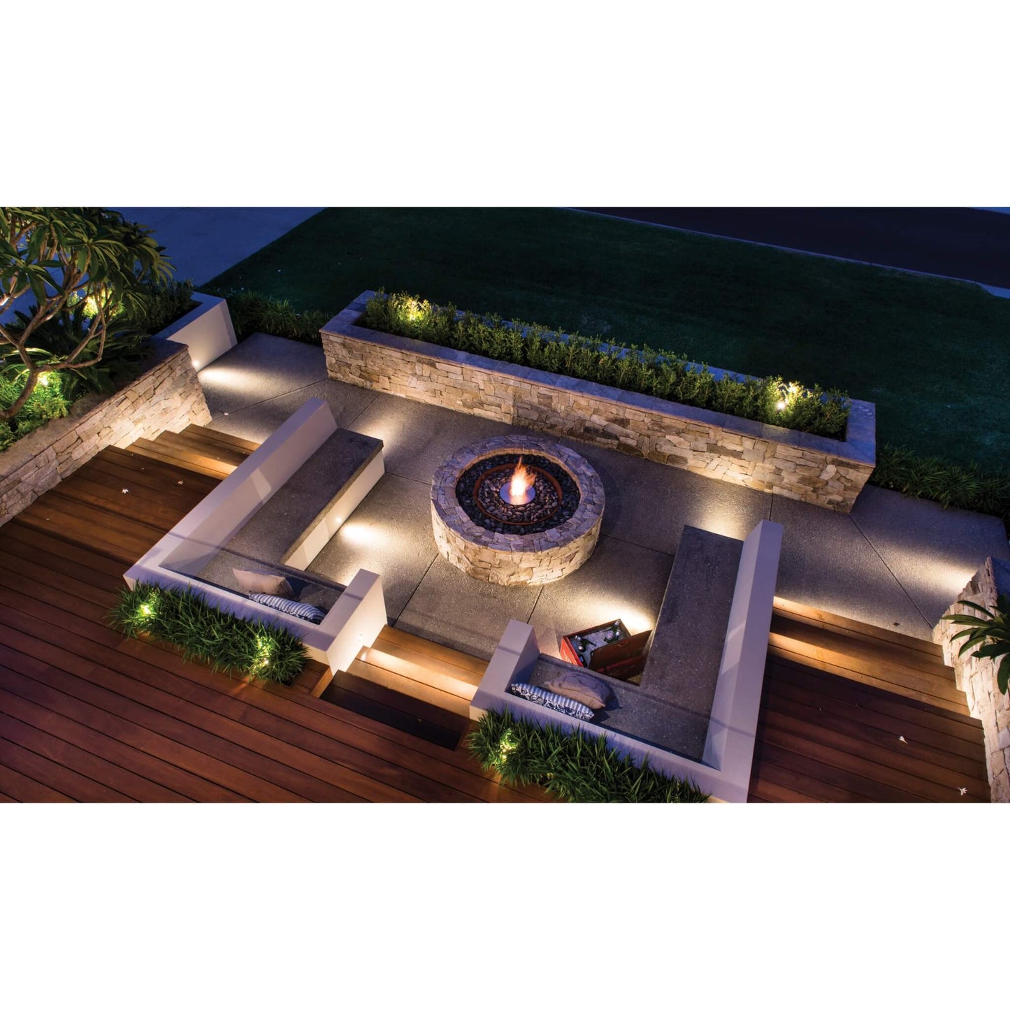 Outdoor patio with fire pit and seating area at night