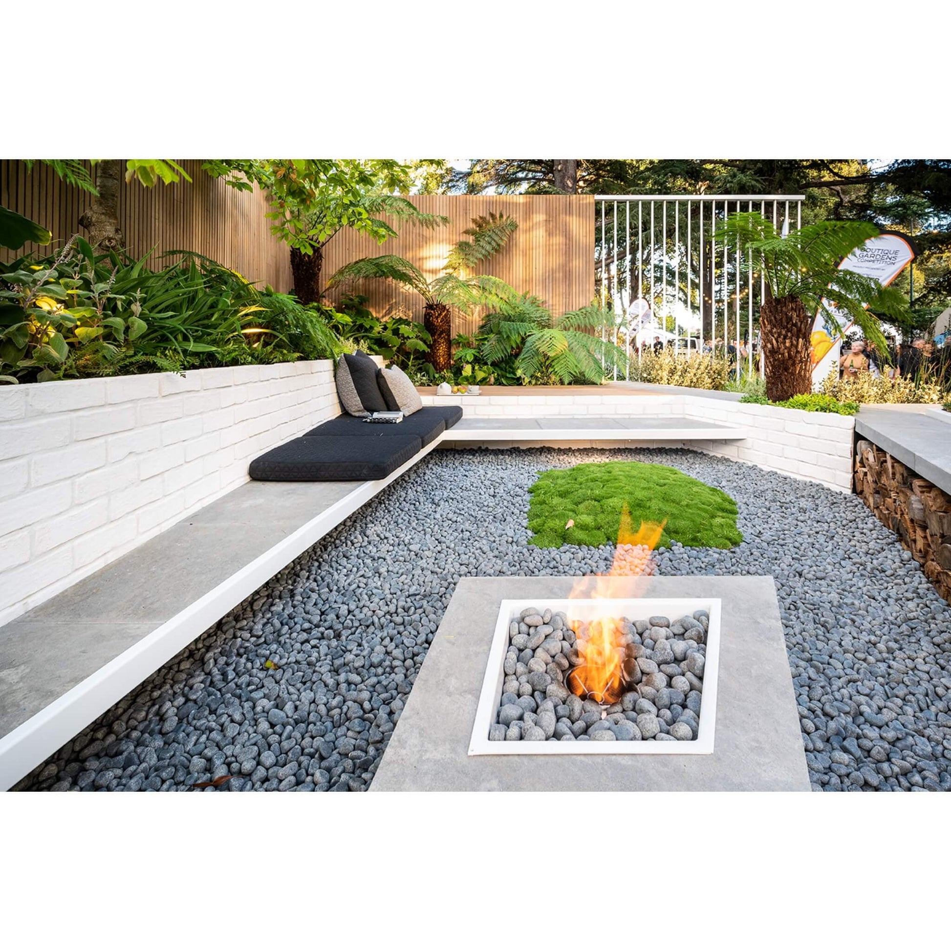 Outdoor fire pit area with seating and greenery